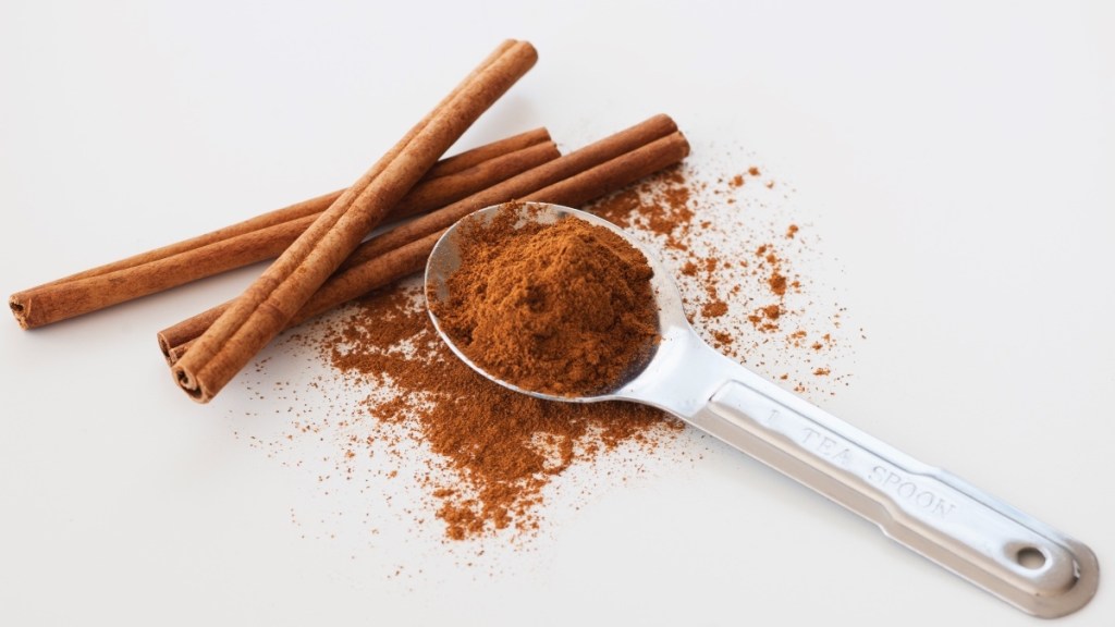 Cinnamon sticks next to a spoon of ground cinnamon, one of the most popular holiday spices