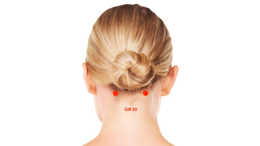 The back of a woman's neck with an illustration of the GB 20 sinus pressure relief point
