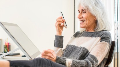 Woman with gray hair using phone speaker