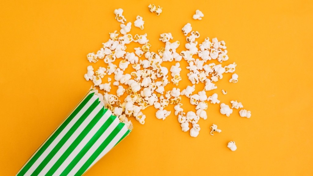 A green striped bag of popcorn on a yellow background, which can help heartburn