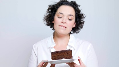 Woman looking at plate of chocolate cake