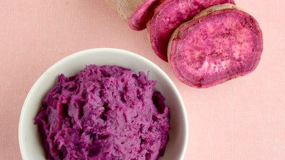 Bowl of mashed ube and sliced purple yam next to it
