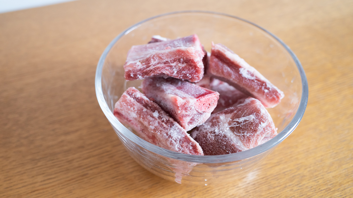 Замороженное мясо в микроволновке. Замороженное мясо на тарелке.