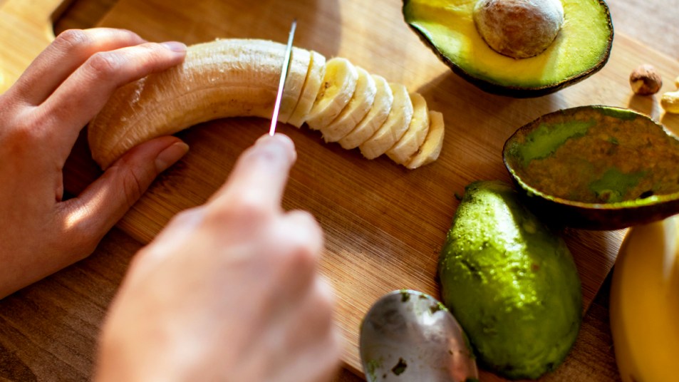 Woman's hand slicing bananas