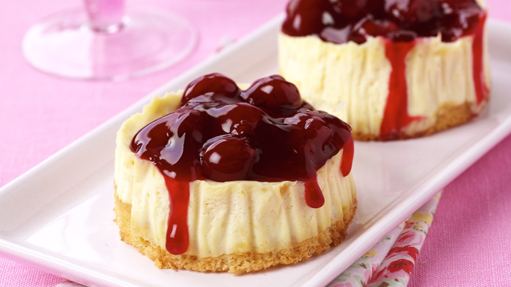 Mini cheesecake on a plate topped with cherry pie filling