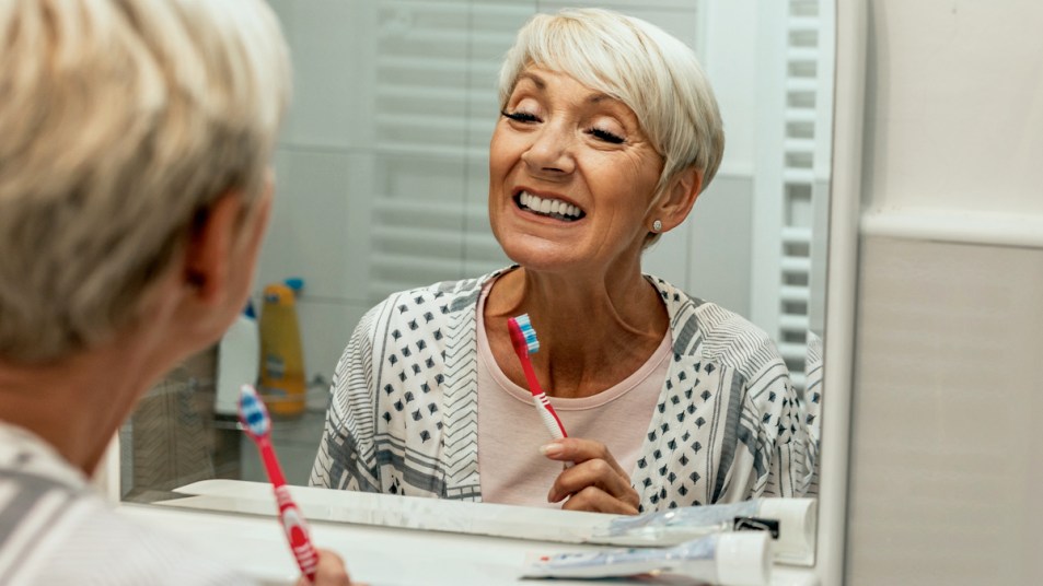Woman looking in the mirror after brushing teeth