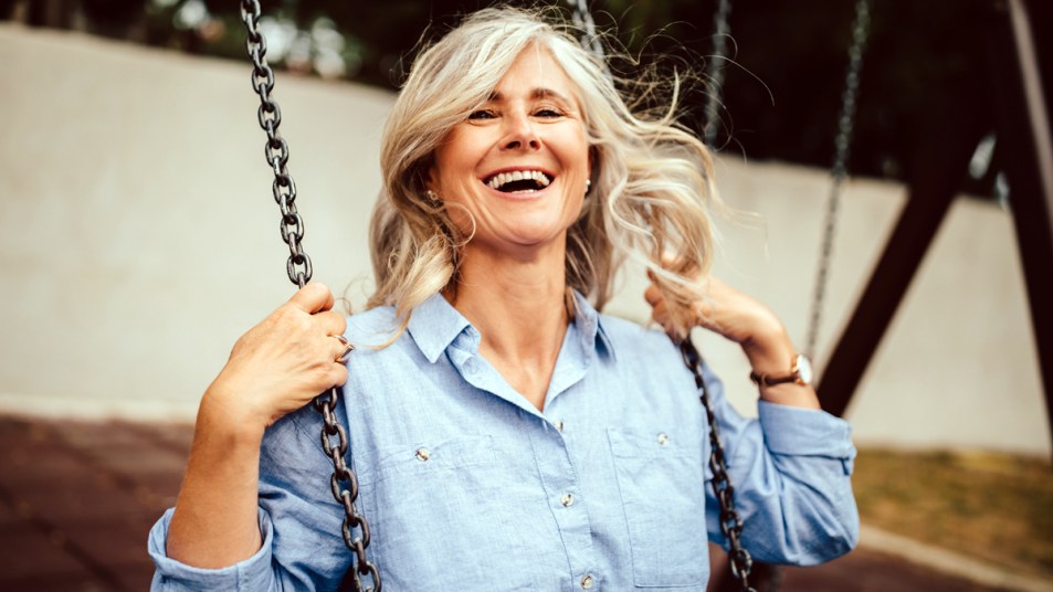 Older woman laughing on a swing