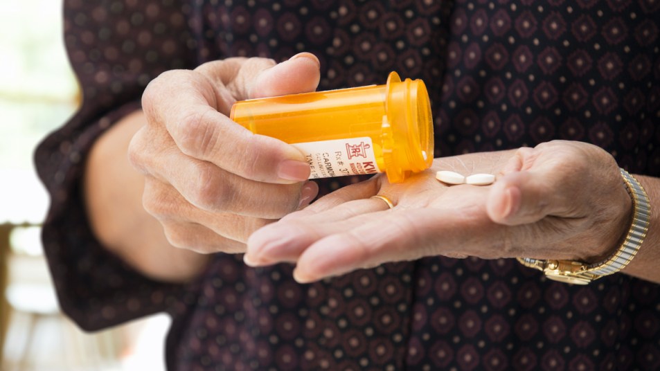 Woman getting pills from a prescription bottle