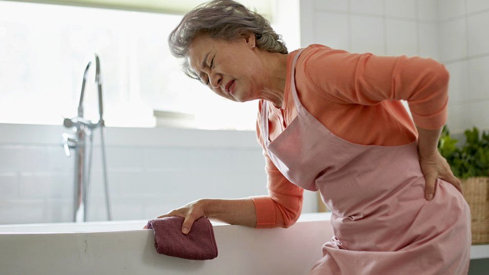 Woman with backache while cleaning