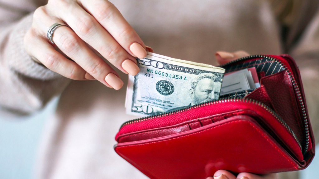 Womans hands taking money out of wallet
