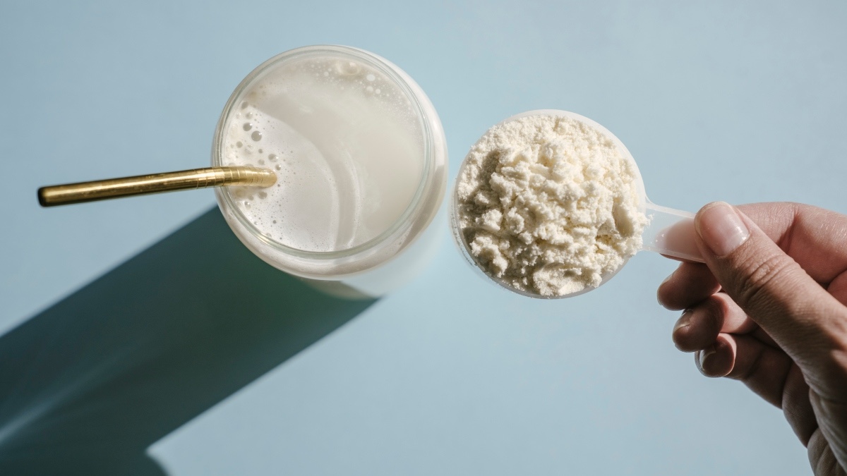 A close-up of a woman putting collagen in a glass to help with weight loss