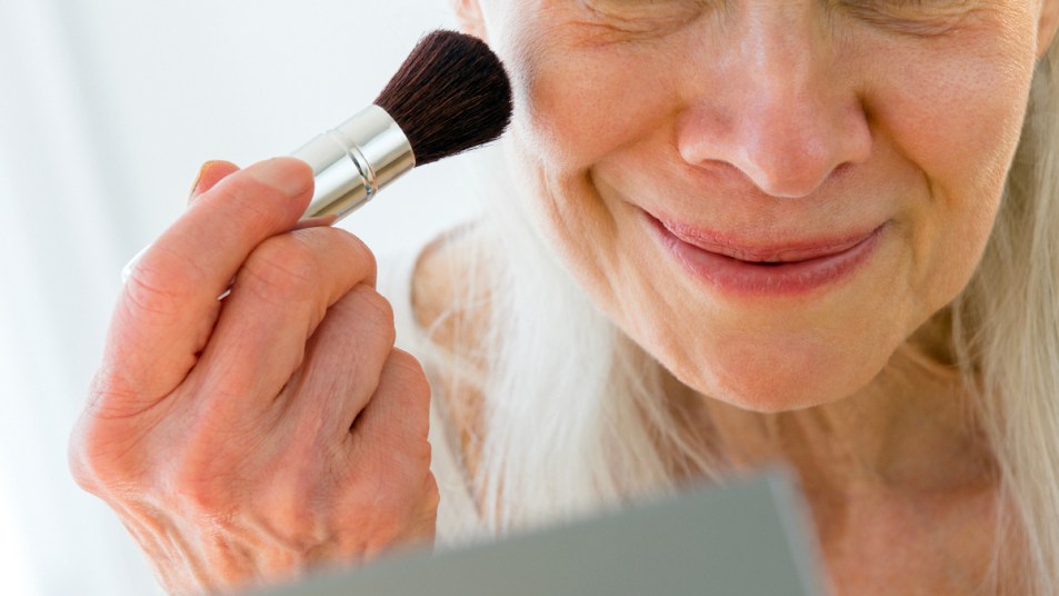 Senior woman applying makeup