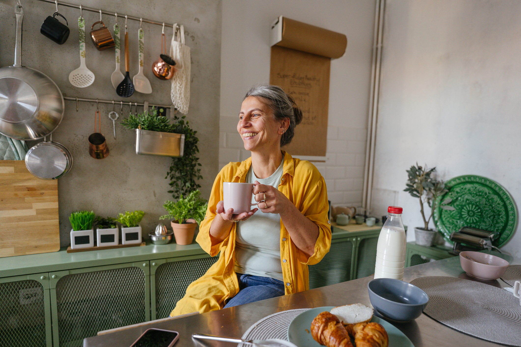 mature woman drinking coffee in kitchen