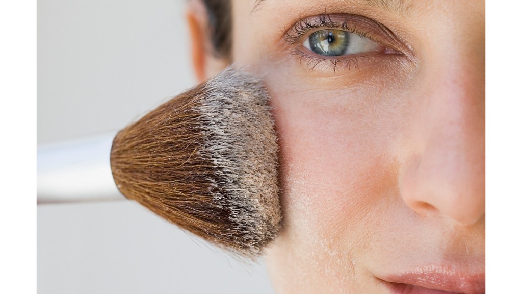 Mature woman using powder on face to bake makeup
