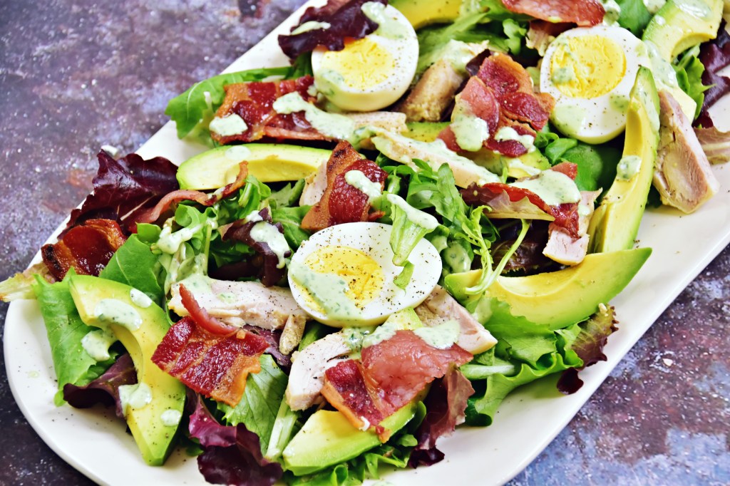 Big salad with lettuce, bacon, hard-boiled eggs and avocado