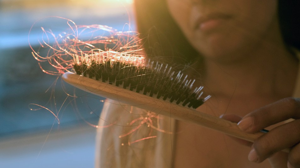 Woman looking at hair brush