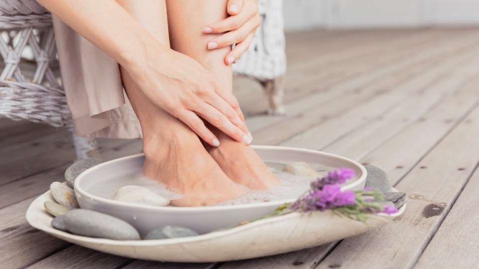 A woman soaking her feet in a garlic foot bath to heal athlete's foot