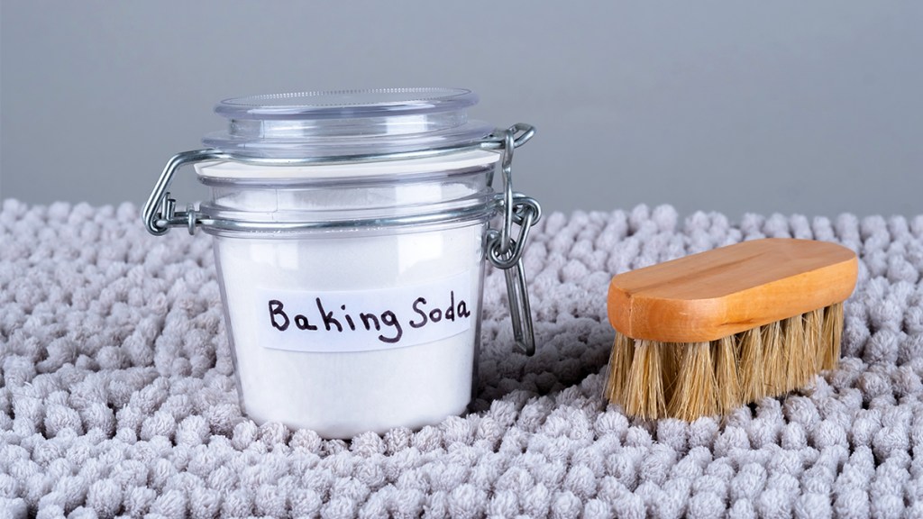 jar of baking soda on a rug with scrub brush nearby; baking soda hacks