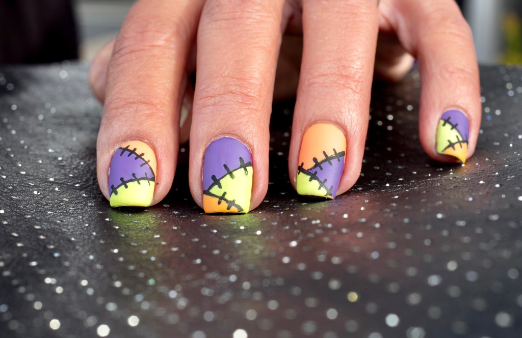 Halloween nails made of orange, green and purple in a patchwork design