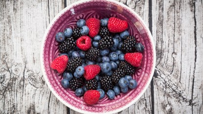 A bowl containing blueberries, raspberries and blackberries, all fruits high in polyphenols that can help heal leaky gut