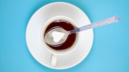Cup of coffee with a spoon full of salt