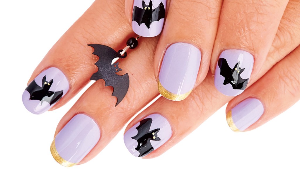 Halloween nails painted with lavender nail polish and bat designs