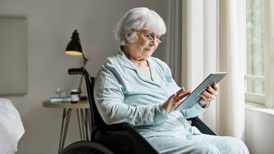 woman in wheelchair using an ipad to connect with loved ones