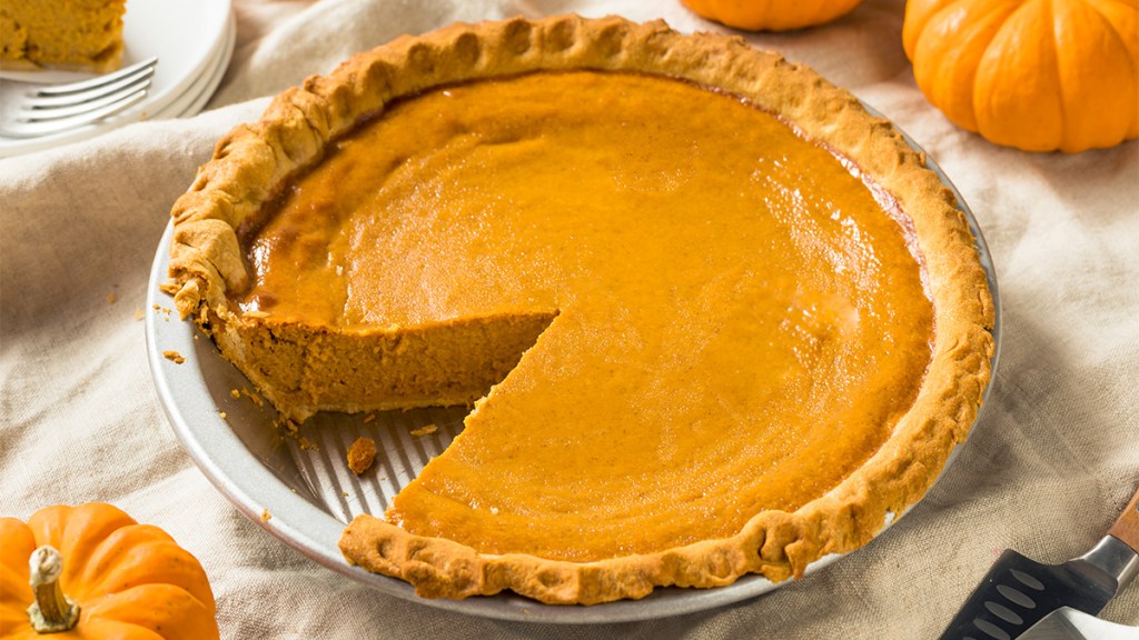 A sour cream pumpkin pie with a slice removed