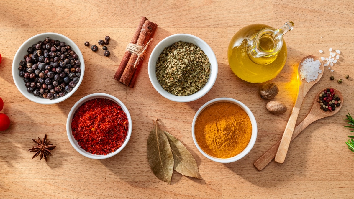 Bowls of various spices and herbs for high blood pressure on a wooden table