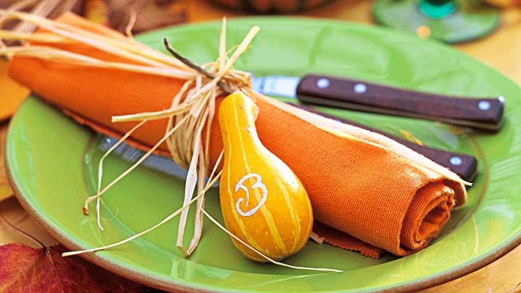 Orange napkin tied with raffia and ornamental gourd