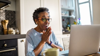 Black woman fighting off loneliness with a smile by connecting virtually on computer