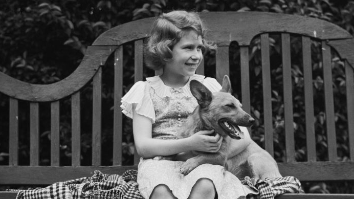 black and white photo of Princess Elizabeth (Queen Elizabeth II) with one of her first Corgis