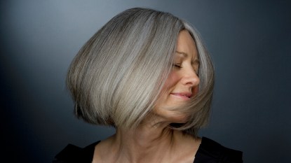 Mature woman turning head, eyes closed, close-up
