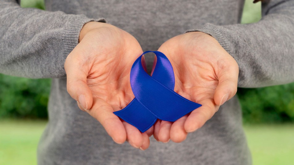 Mature female hands holding an animated colon cancer awareness ribbon.