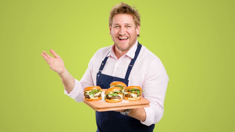 chef curtis stone holding a platter of burgers