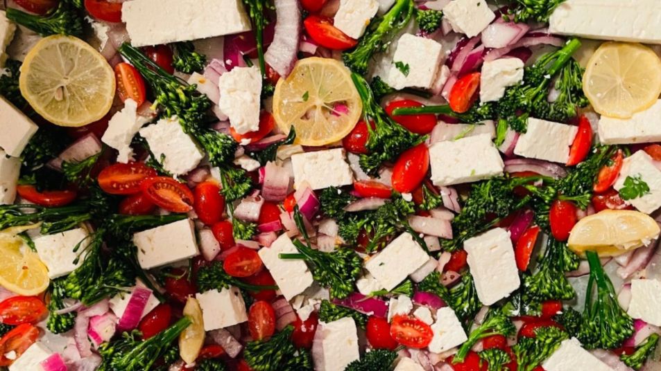 sheet pan dinner with roasted broccoli, tomatoes, lemon, and feta before roasting