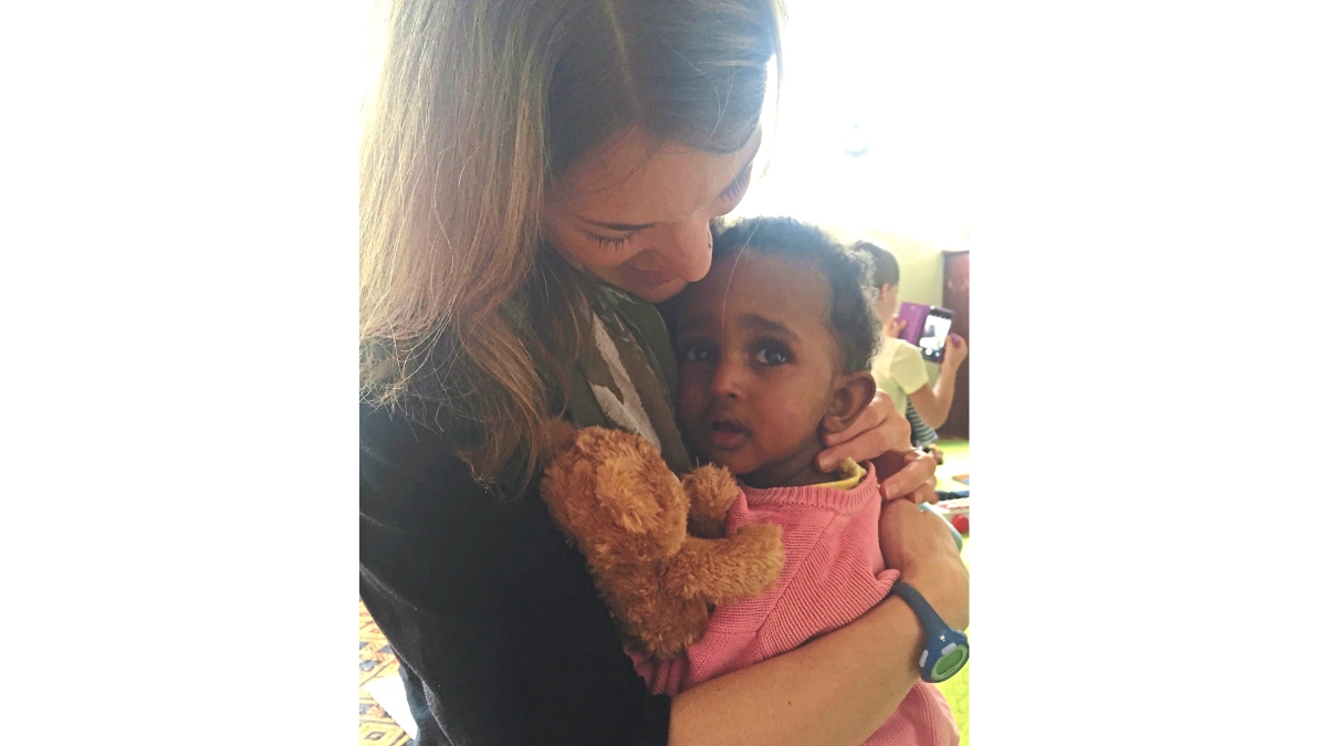 Naomi, holding Teddy, in orphange with adoptive mom, Addie