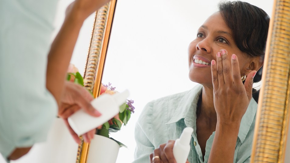 Woman applying moisturizer to her skin