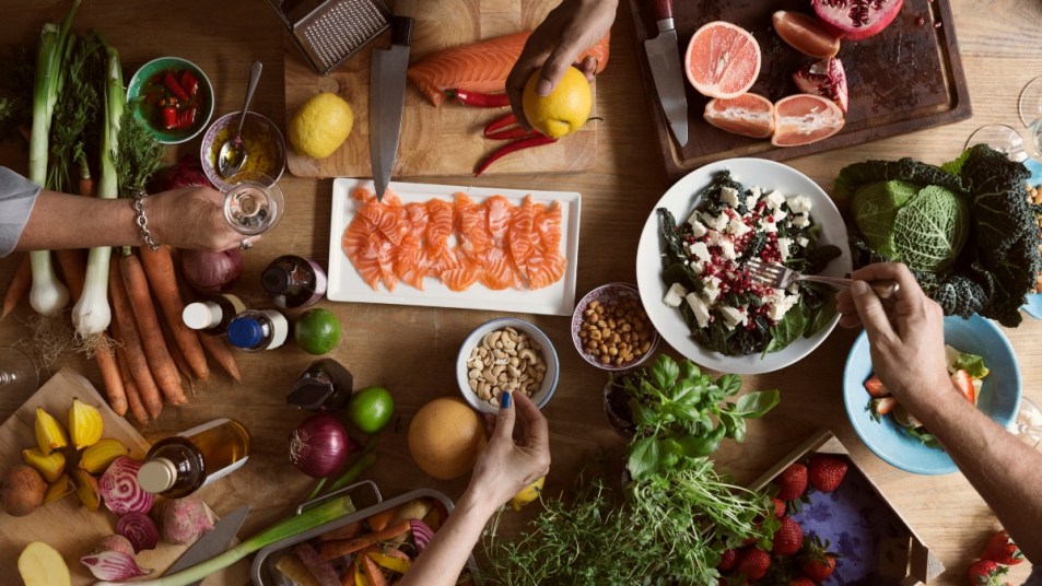 birds-eye view of Nordic diet staples on a table, including salmon and root vegetables