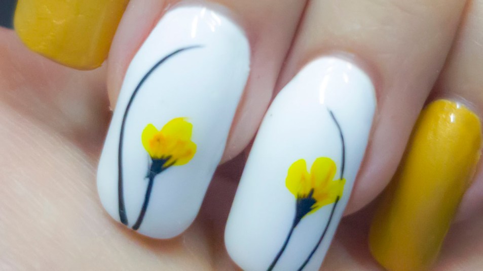 Spring nail art design with yellow tulips on fingernails.