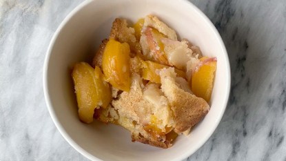 A-bowl-of-lazy-homemade-peach-cobbler-on-marble-cutting-board