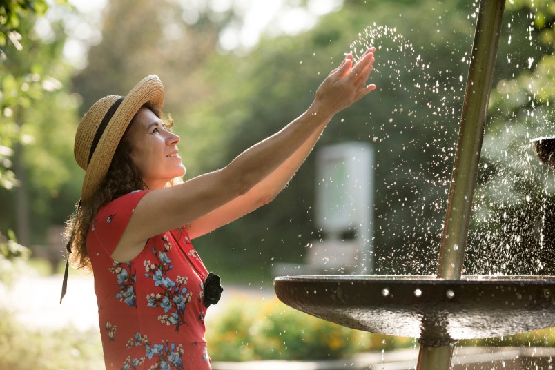 woman splashing in fountain
