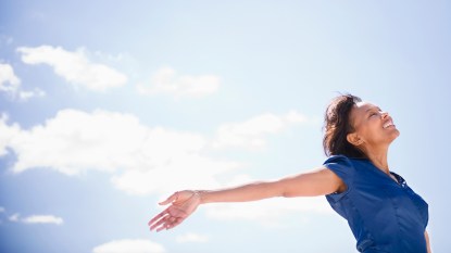 woman feeling happy outdoors blue sky