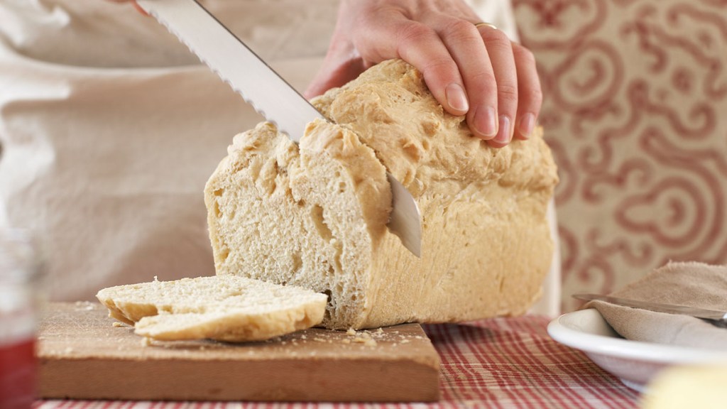 Person slicing into a loaf of egg white bread made for the PSMF diet