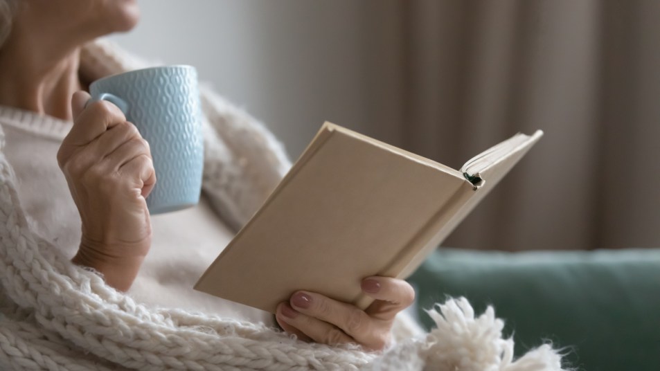 woman-reading-book-while-sipping-coffee