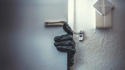 gloved hand trying to open a door, burglar