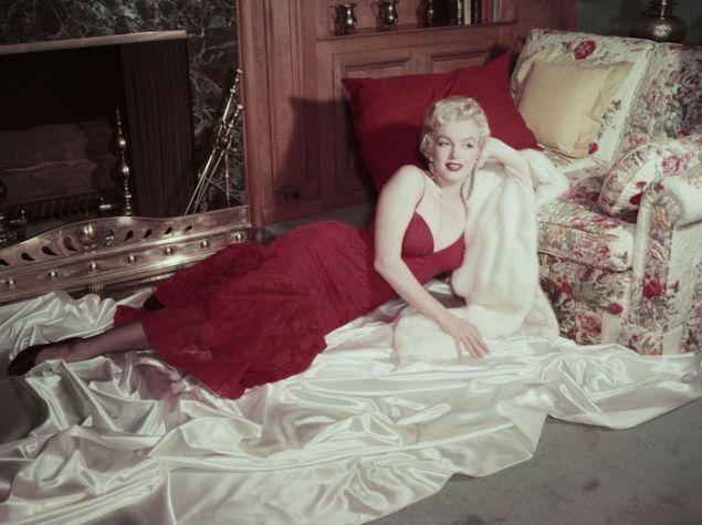 Marilyn Monroe sitting in red dress