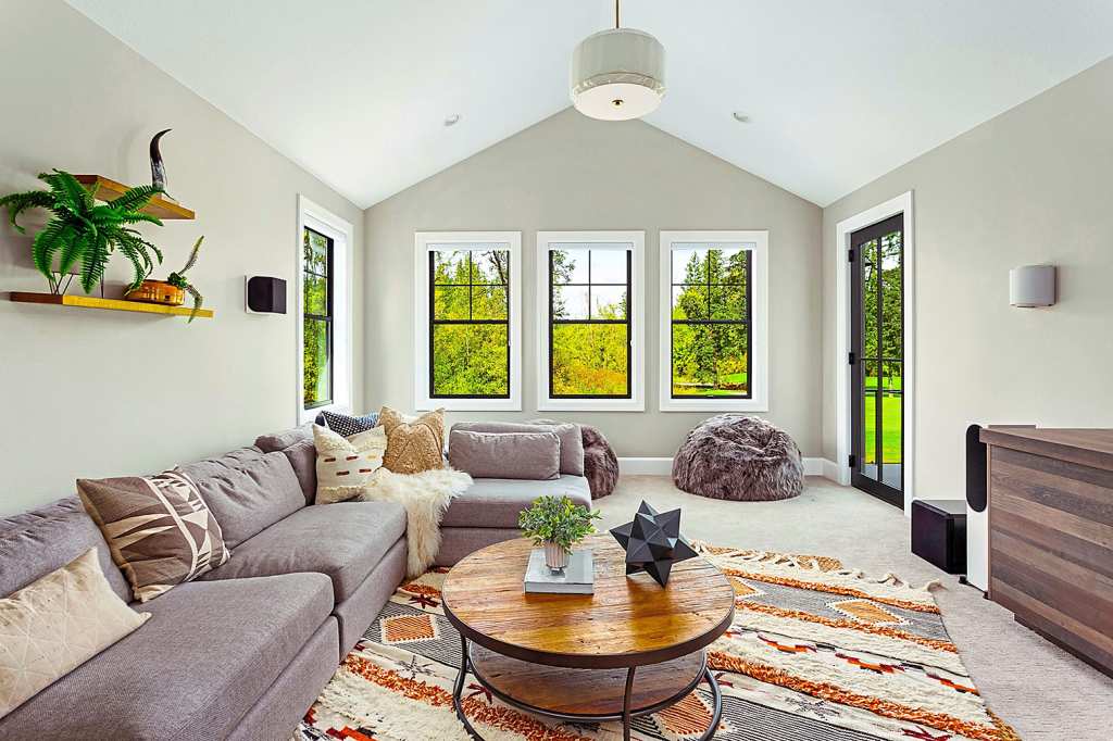 Beautiful living room interior with colorful area rug, large couch, and abundant natural light