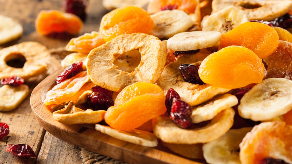 A wood table filled with dried fruit like cranberries and apricots, which are a potassium-rich food