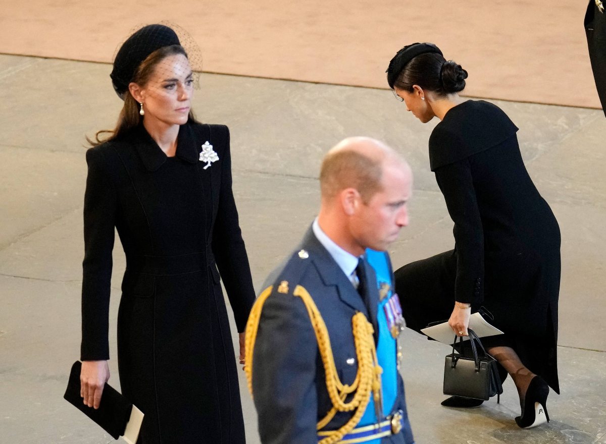 Kate Middleton wearing pearl and diamond brooch, Prince William and Meghan Markle beside her